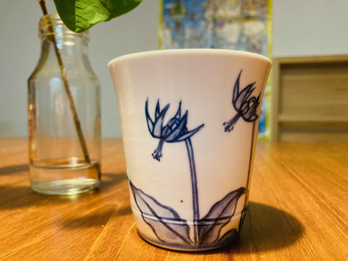 白地に青でカタクリの花が描かれたカップ